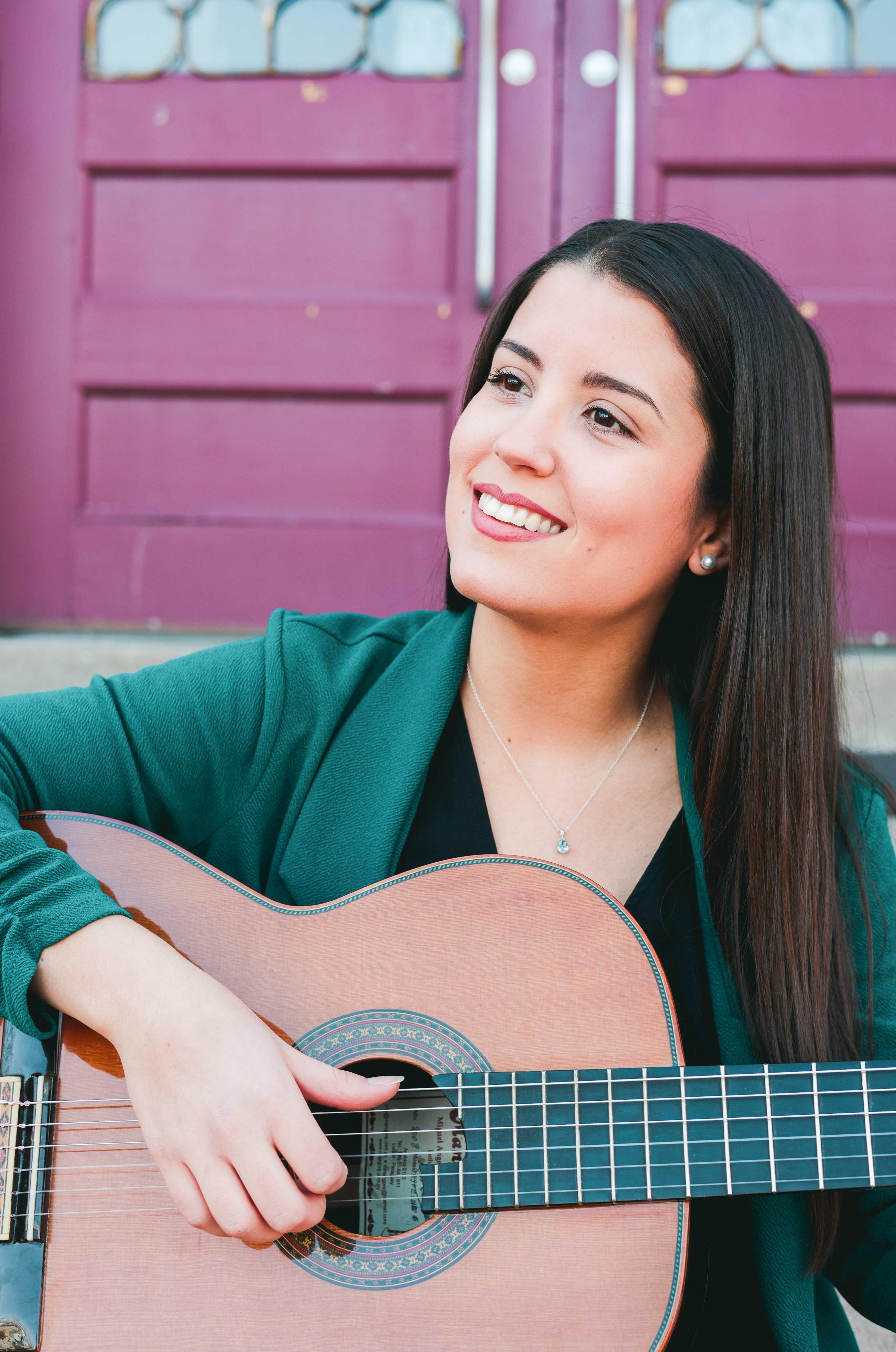 woman playing a guitar and smiling