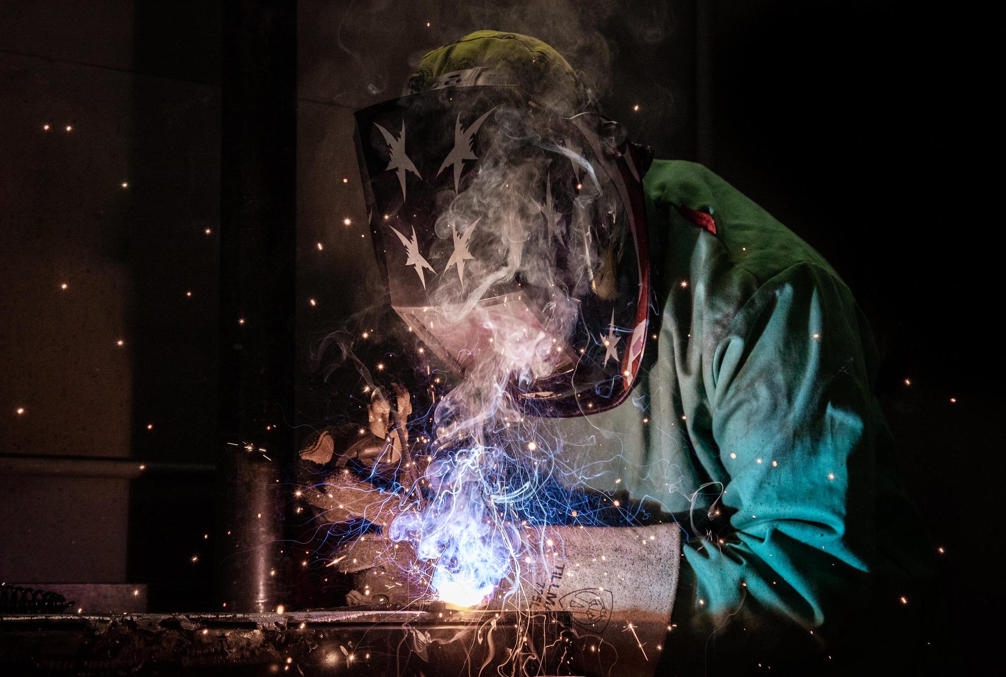 a welder welding with bright light and sparks flying