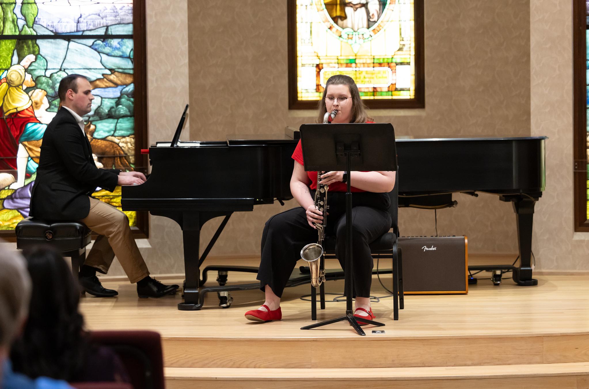 student playing an instrument with a pianist in the background