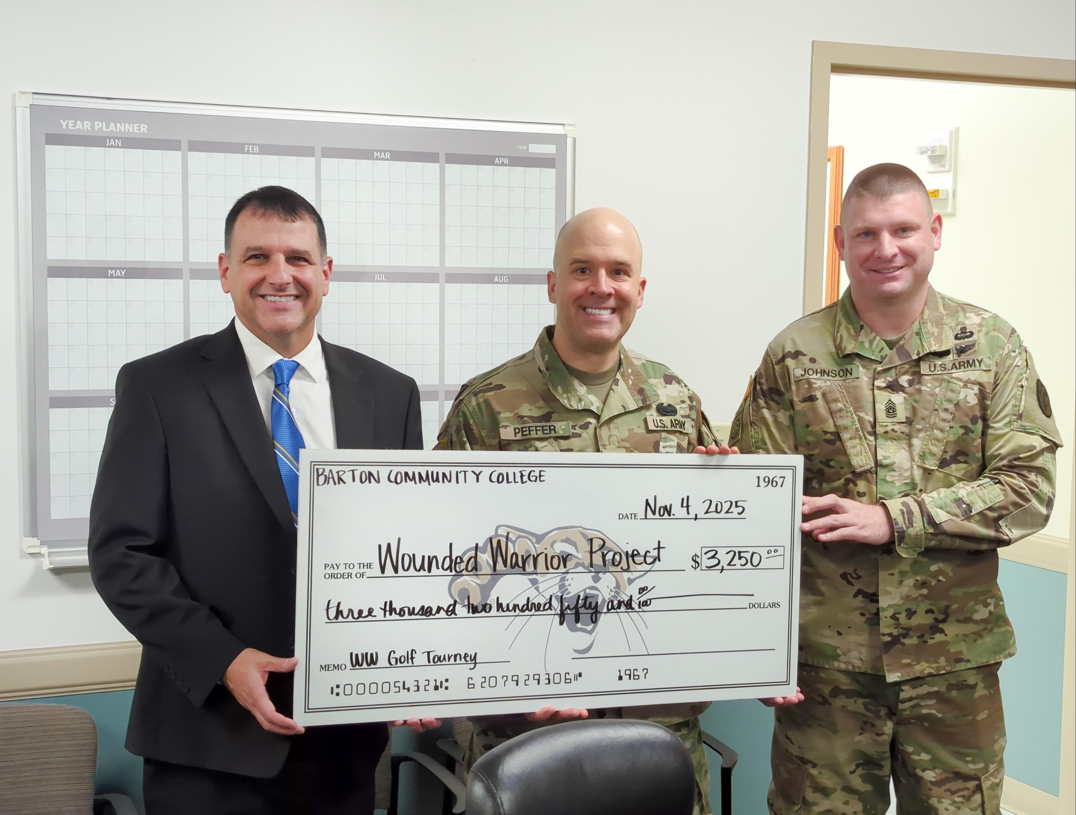college president standing with two army officers in fatigues holding  a check
