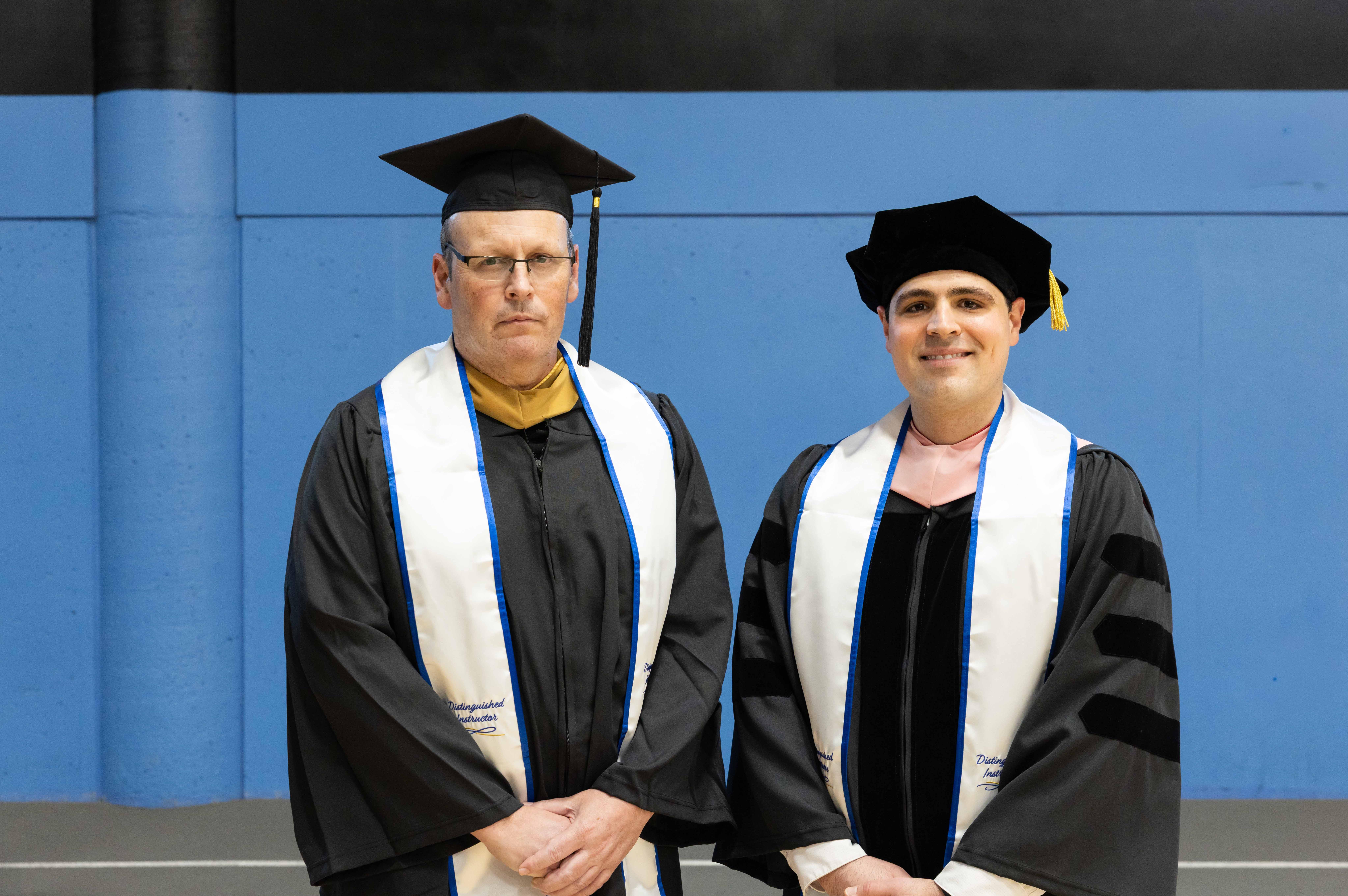 two men in graduation regalia 