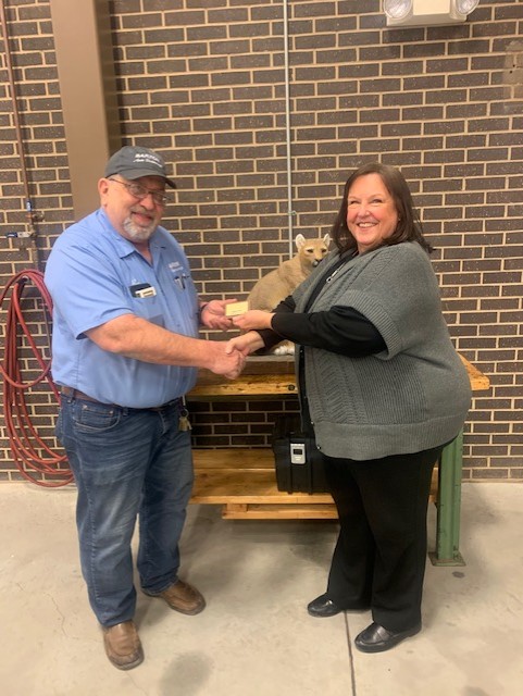 Automotive Technology Instructor Ron Kirmer accepts a retirement brick from Dean of Workforce Training and Community Education Kathy Kottas.