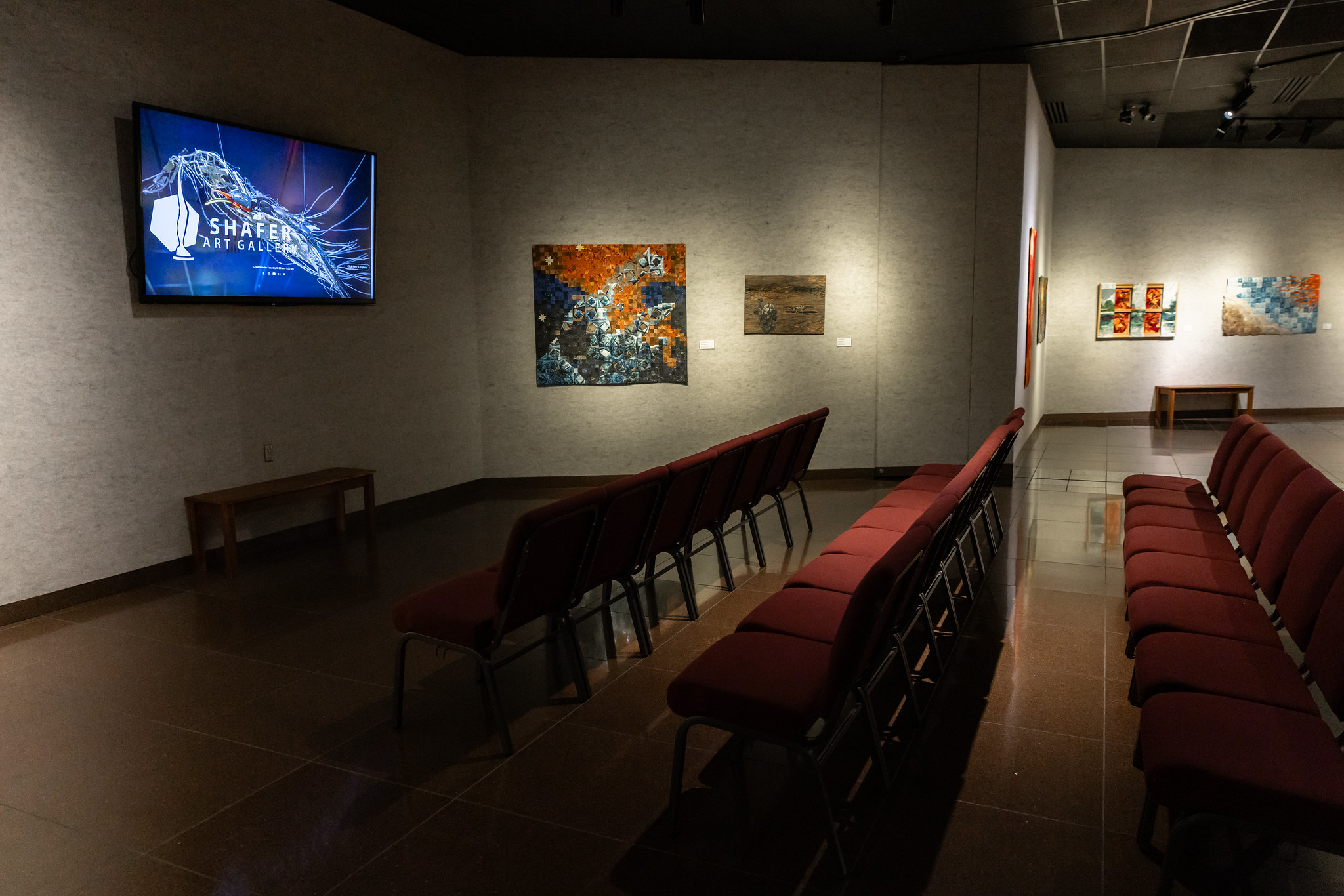 tv on wall with chairs in gallery
