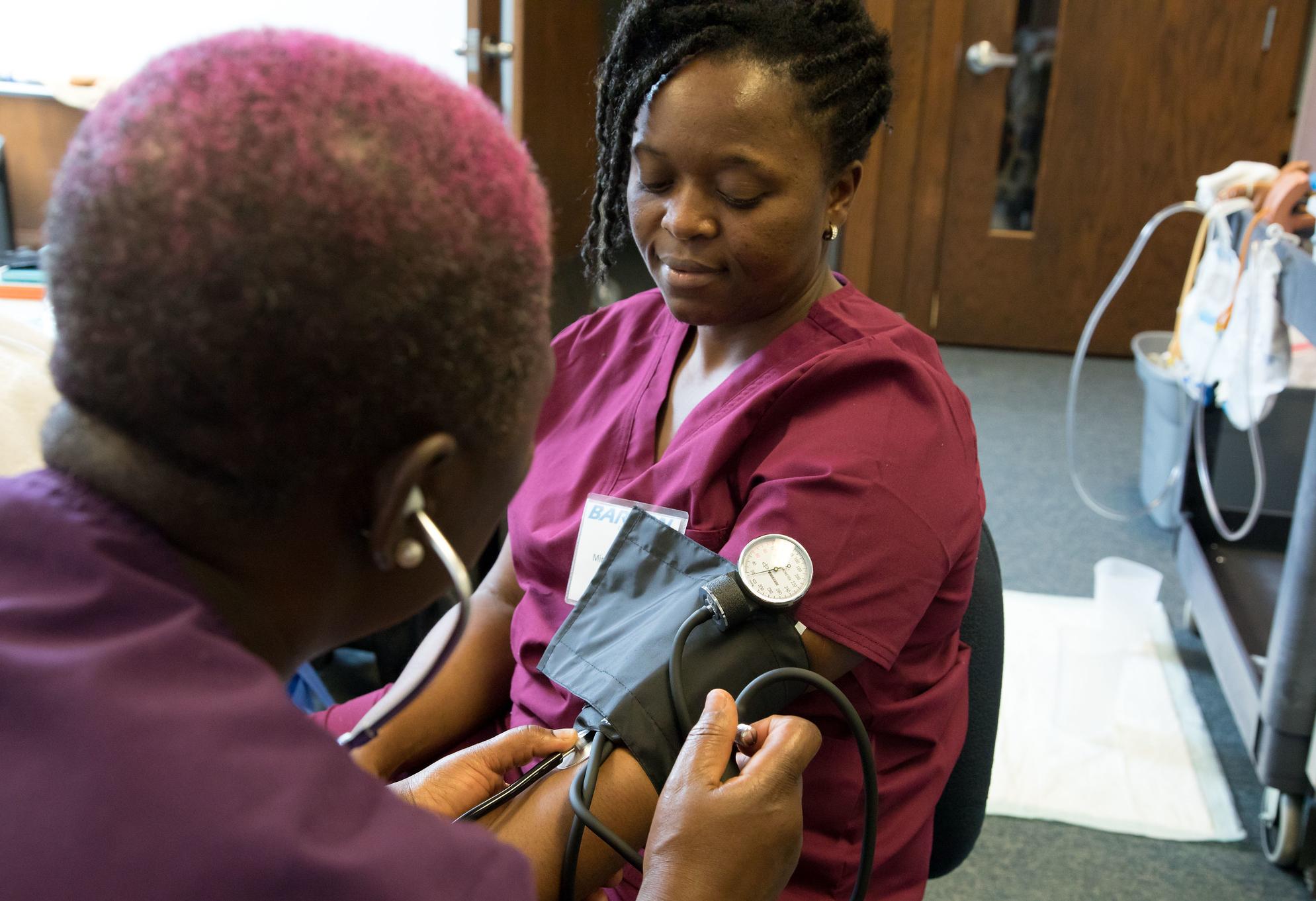 woman taking another woman's blood pressure