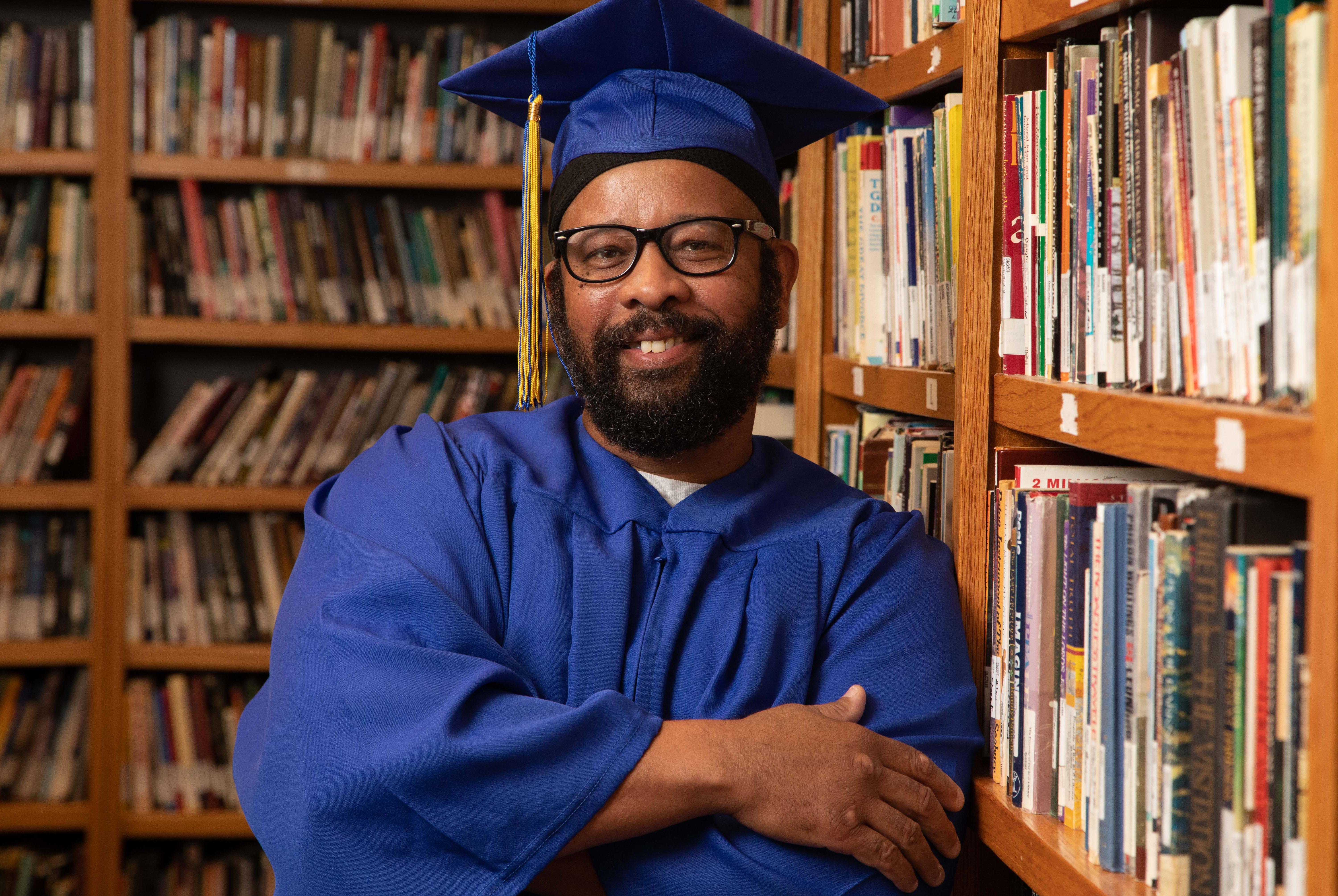 ECF resident Richard Johnson poses before the learning celebration Wednesday in the library at the ECF Spiritual Life Center. Johnson, who began his sentence in 1993 and will release in 2036, earned a high school diploma through a program offered by Barton Community College.