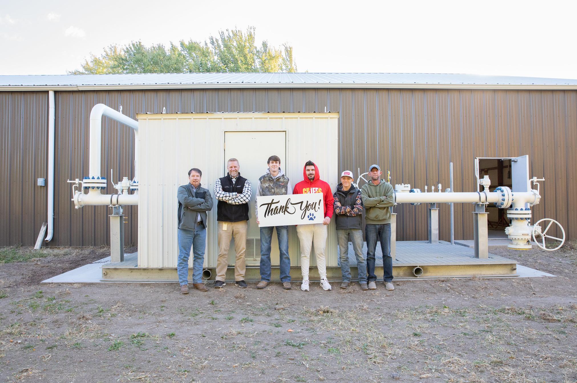 students and southern star representatives pose in front of large piece of equipment