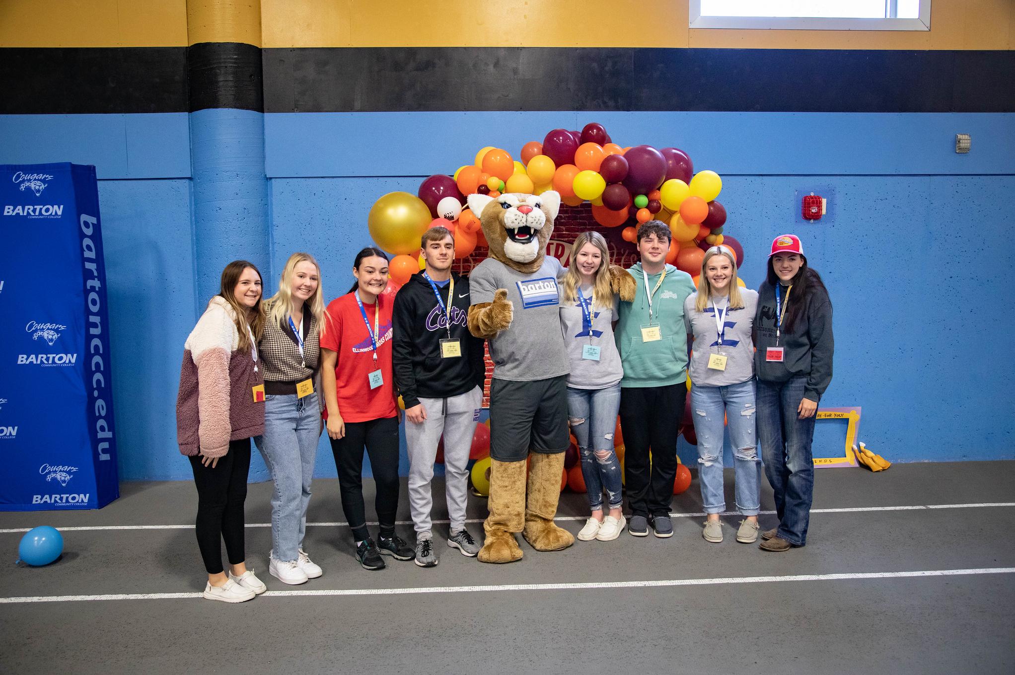 students standing with a cougar mascot