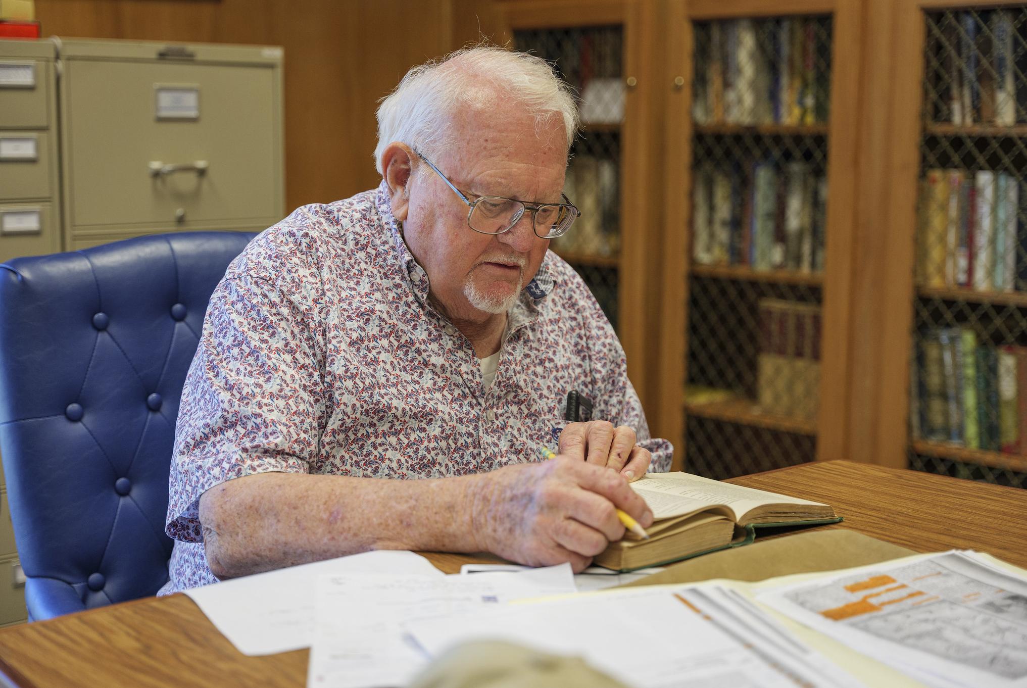 older man looks at a book intently