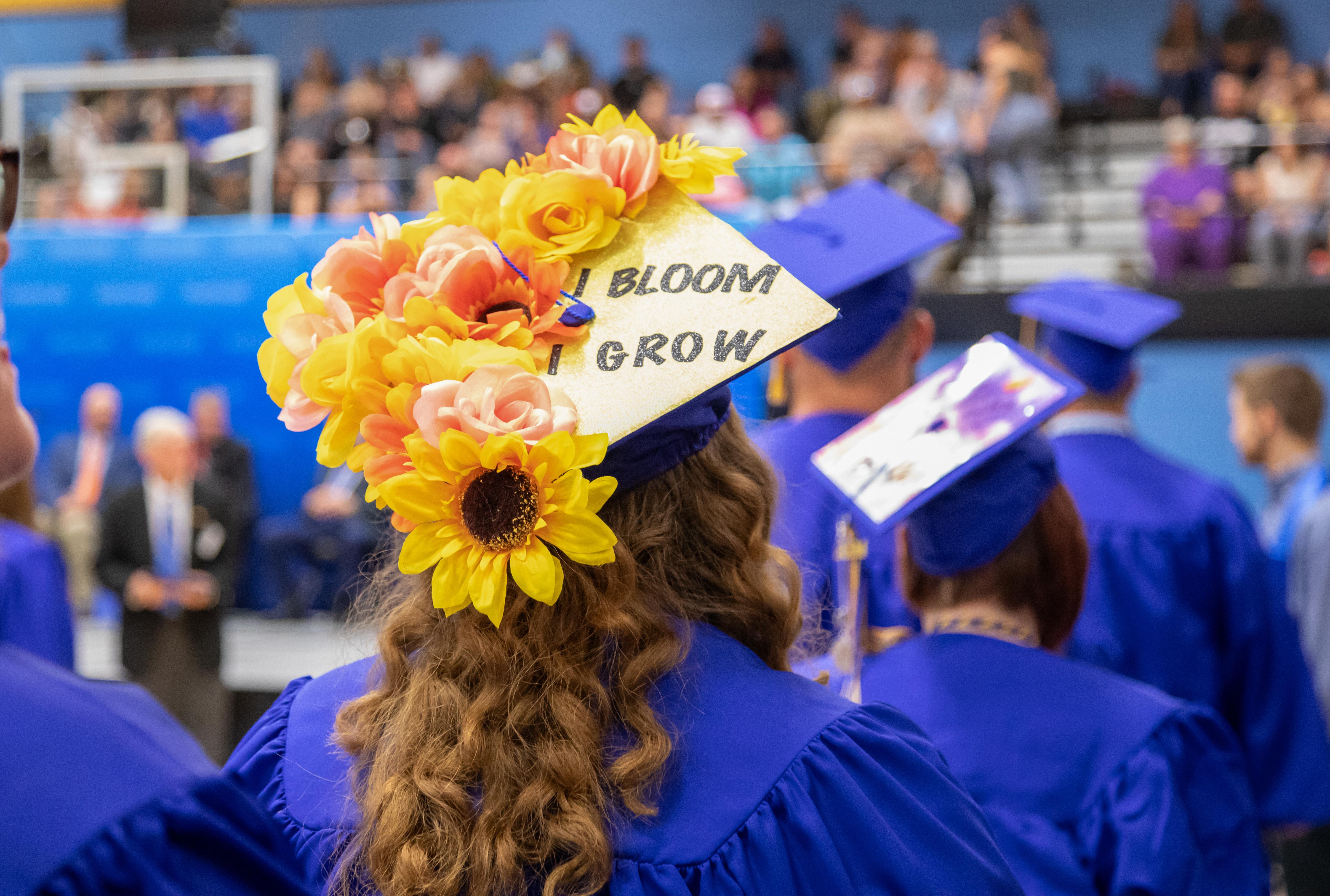 graduation cap with flowers on it says "i bloom i grow" on it