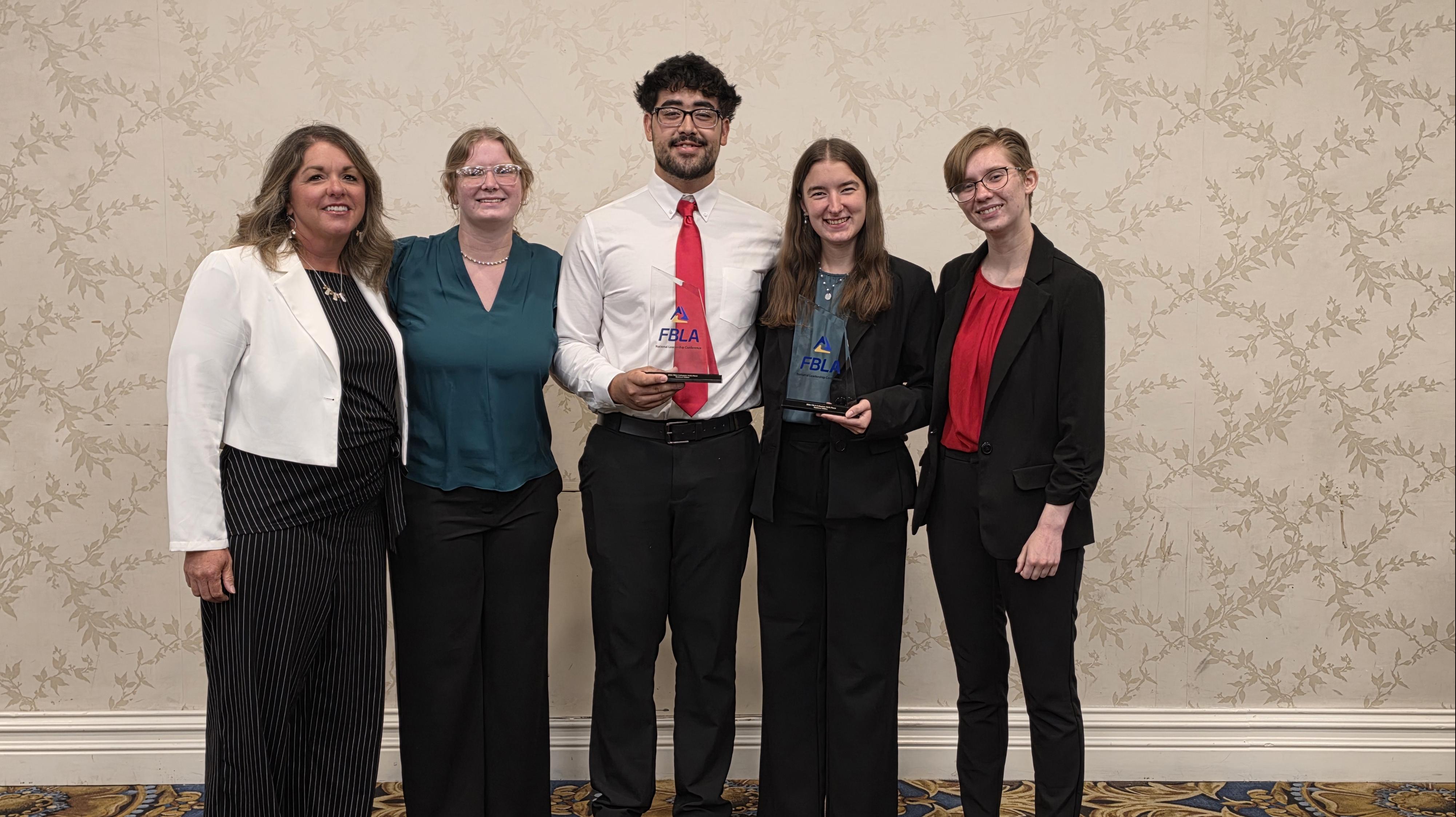 people smiling and holding awards