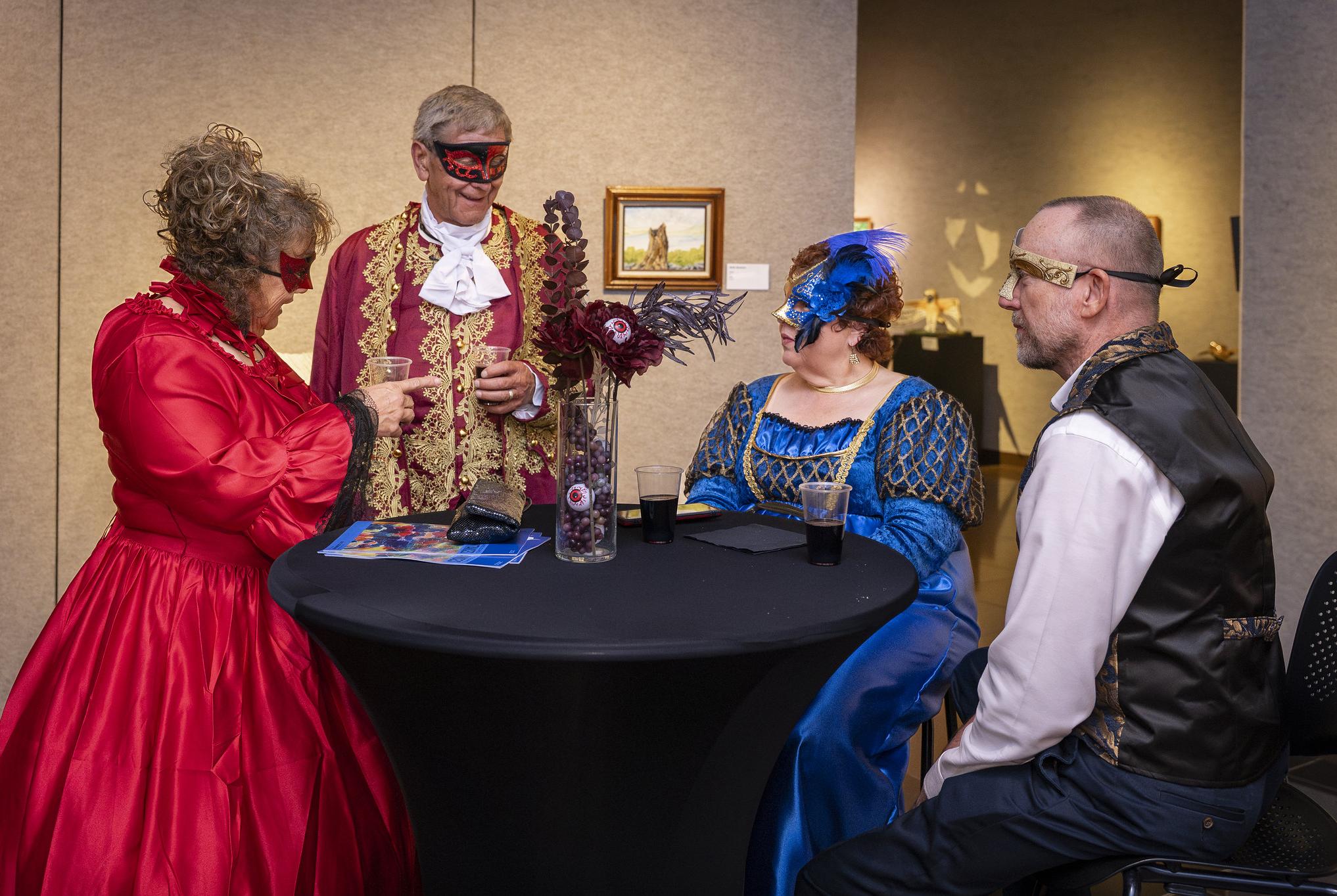 people in victorian costumes at a table